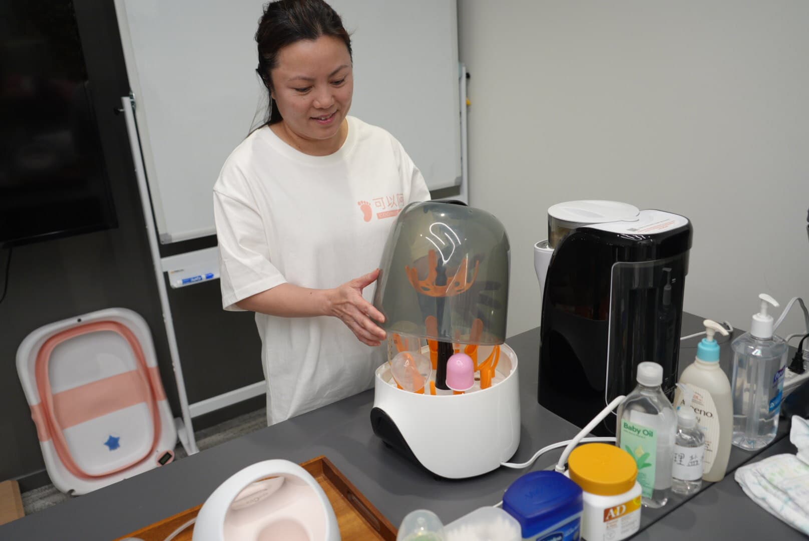 Trainer demonstrating bottle sterilizer equipment