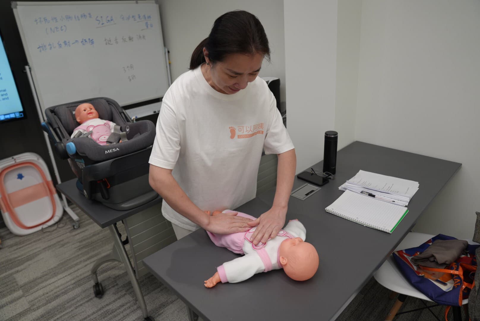 Doula practicing postpartum care techniques on a mannequin